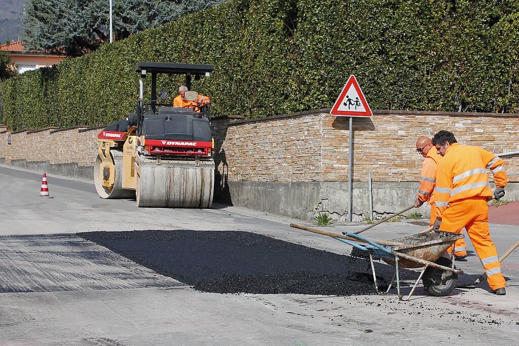 Uomini impegnati nei lavori di asfaltatura