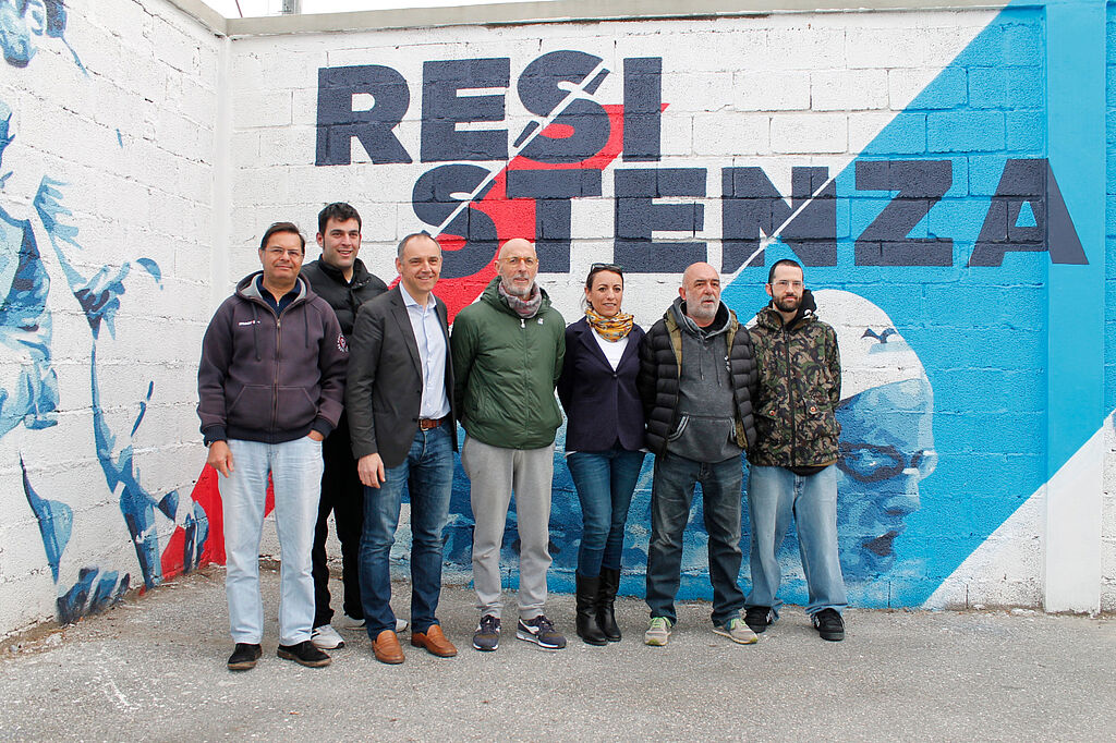 Il sindaco Menesini, l'assessore Miccichè, l'artista Freddy Pills e i rappresentanti della Folgor Marlia davanti a un murales